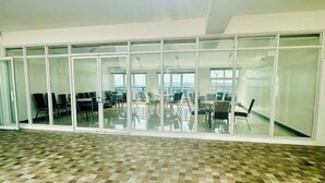 A spacious indoor area with a checkered floor, large windows, and a view of the sky.