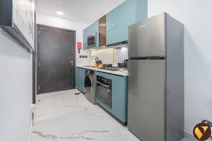 Estudio de lujo, balcón, vistas a la ciudad | Cocina privada | Frigorífico grande, microondas, horno y placa de cocina