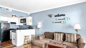 A compact living space with a kitchenette, a sofa set, and a coffee table. - Destination Ocean, Unobstructed Oceanfront Suite with a King Bed (Myrtle Beach)