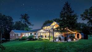 A house with a well-lit porch, a covered outdoor seating area, and a cylindrical structure. - Bourbon Trail Estate, Golf Sim, SpeakEZ, Sleeps 14 (Frankfort)