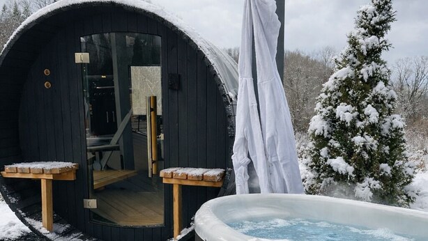 Ein Whirlpool und eine Sauna in verschneiter Umgebung.