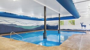 An indoor swimming pool with clear blue water, tiled flooring, and a mural depicting mountains and a deer on the wall. - Modern Family Lodge 1 Mi to Silver Dollar City, Indoor Pool, Hot Tub, Arcade, EV (Branson)