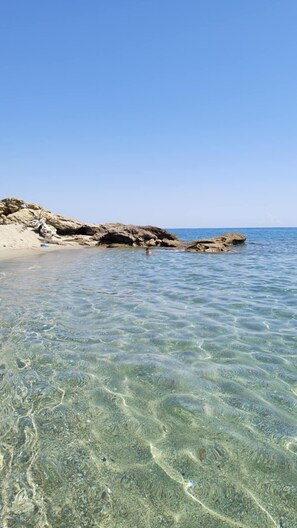 A clear beach with rocky formations and calm water. - 42 sq.m. air-conditioned apartment in Marina di Bravone, 200 m. from the beach (Linguizzetta)