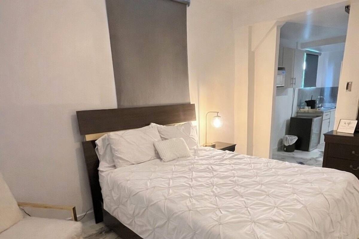 Une chambre à coucher avec un lit, une chaise et une table de chevet.