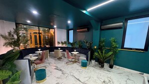 Un espace de détente moderne avec un sol en marbre, des sièges confortables et des plantes en pot.