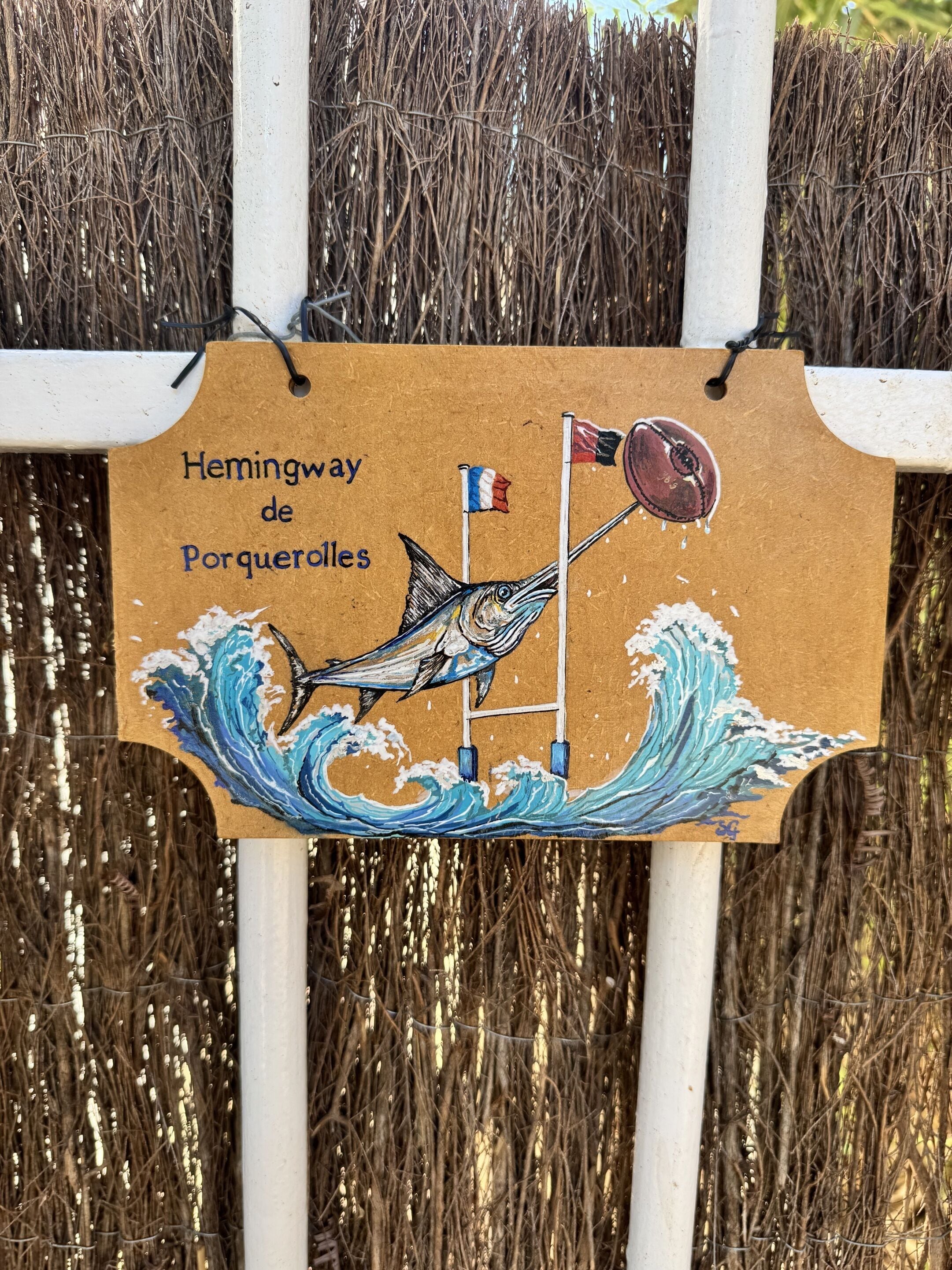Senyal amb un dibuix d'una barca i ones, i el text 'Hemingway de Porqueroles'.