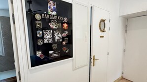Un couloir avec un panneau mural présentant différents emblèmes d’équipes sportives et une photographie encadrée.