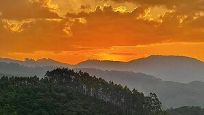 Un paisaje montañoso boscoso durante el atardecer.