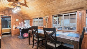 Un intérieur en bois avec une table, des chaises et un baby-foot.