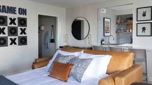 A bedroom with a bed, a desk, and a bathroom. - Downtown ATL Condo Balcony (Atlanta)
