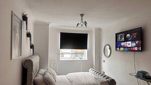 A bedroom with a bed, a TV mounted on the wall, a window, and a ceiling light. - One Bedoom Flat in Birmingham City Centre With Free Underground Parking (Birmingham)