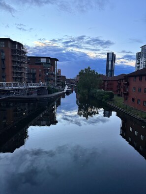 A calm river with buildings on either side, including a bridge and a tall skyscraper. - Charming Birmingham Apartment With Mini Balcony and Wifi With a Free Parking (Birmingham)