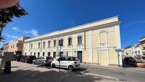 Un bâtiment à la façade jaune, sur lequel on peut voir une enseigne indiquant un espace de stationnement.