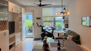 A modern kitchen with a dining area, a ceiling fan, and a view of the outdoors. - Jr 1 BR w/ parking & a plunge in Design District (San Francisco)