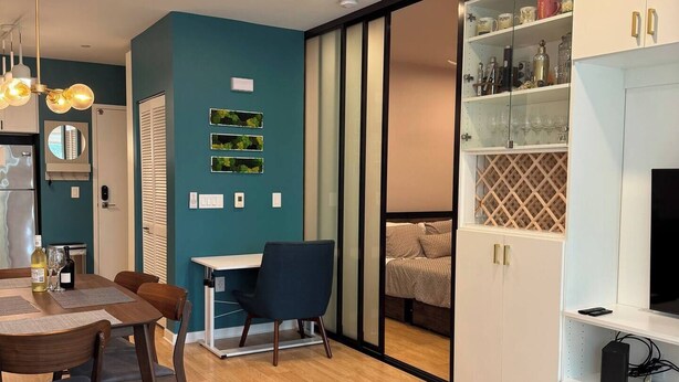 A modern living room with a dining area, a glass coffee table, and a TV stand. - Jr 1 BR w/ parking & a plunge in Design District (San Francisco)
