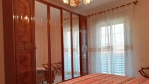 Une chambre à coucher avec un grand lit, une armoire et une chaise.