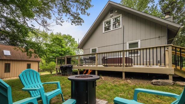 Un jardin avec un foyer, deux fauteuils Adirondack et une terrasse.