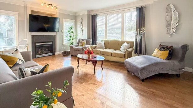 A living room with a fireplace, sofas, a coffee table, and a TV.