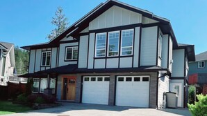 A two-story house with a garage, a front porch, and a driveway.