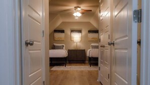 A bedroom with two beds, a ceiling fan, and a nightstand. - Spacious Home in South Tulsa- Finale Home. Close to major highways and Riverside (Tulsa)