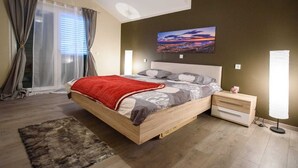 A bedroom with a bed, bedside tables, a rug, and a painting on the wall. - Vacation home near Split with private pool & garden (Kaštel Lukšić)