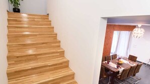 A wooden staircase leading to a dining area with a table set for four. - Vacation home near Split with private pool & garden (Kaštel Lukšić)