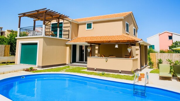 A two-story house with a swimming pool, a covered patio, and a fenced backyard. - Vacation home near Split with private pool & garden (Kaštel Lukšić)