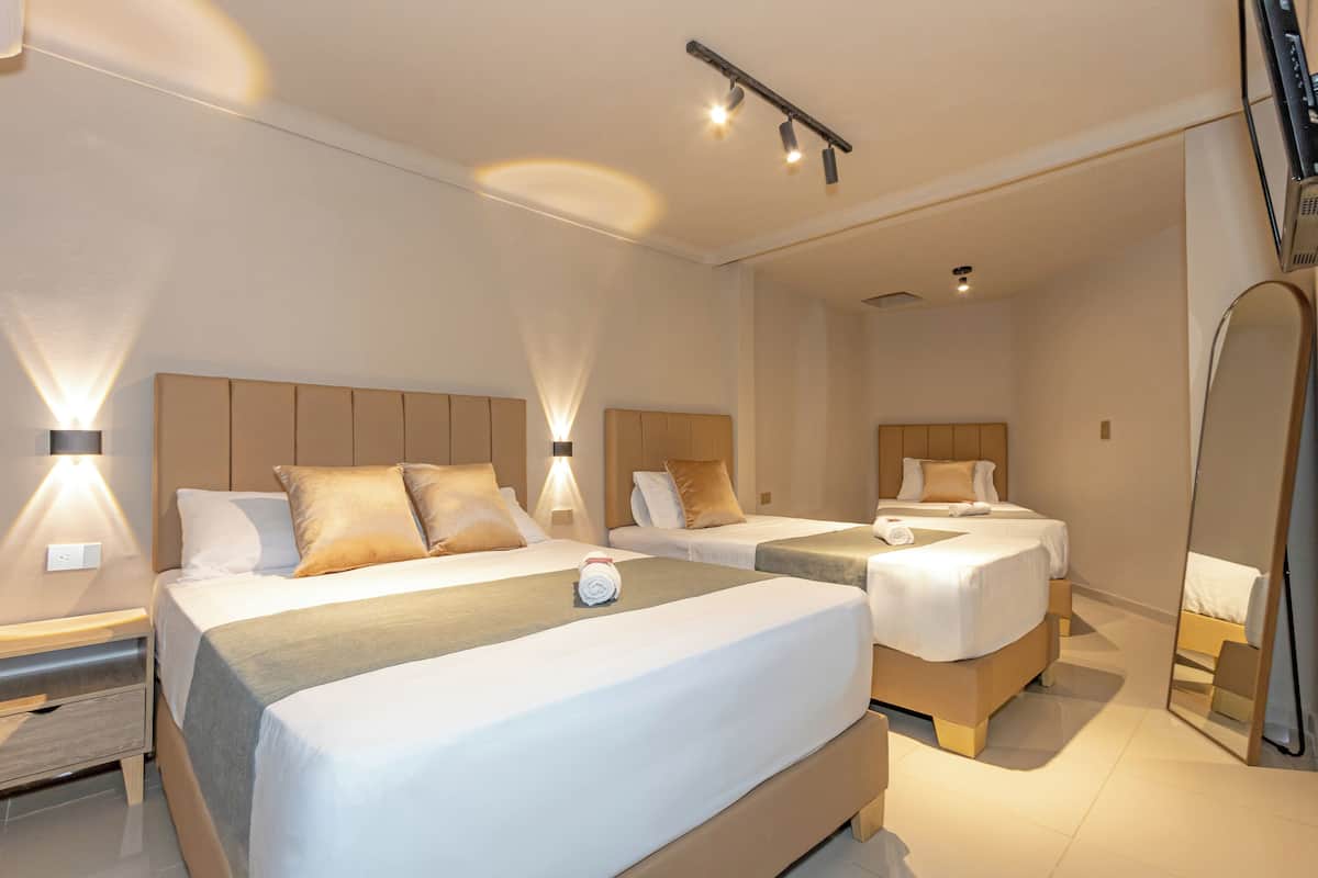 Ein Hotelzimmer mit zwei Betten, einem Nachttisch, einem Spiegel und einer Deckenleuchte.