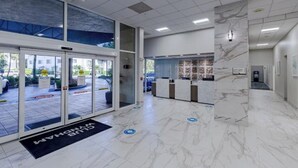 A hotel lobby with a reception desk, a glass door entrance, and a marble floor. - 2bed/2bath Club Wyndham Santa Barbara resort. Across St frm Pompano Beach w/pool (Pompano Beach)
