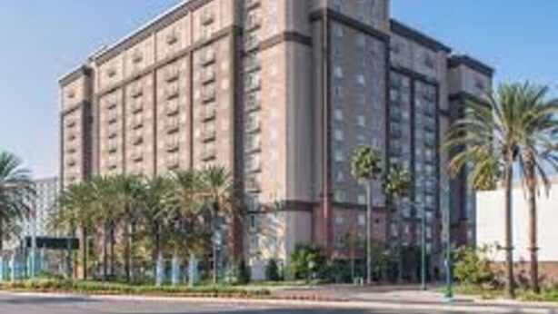 A multi-story hotel with a symmetrical facade, featuring a central entrance and uniform window patterns.