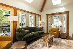 Un salon chaleureux avec un canapé vert, un fauteuil jaune et une table basse en bois.