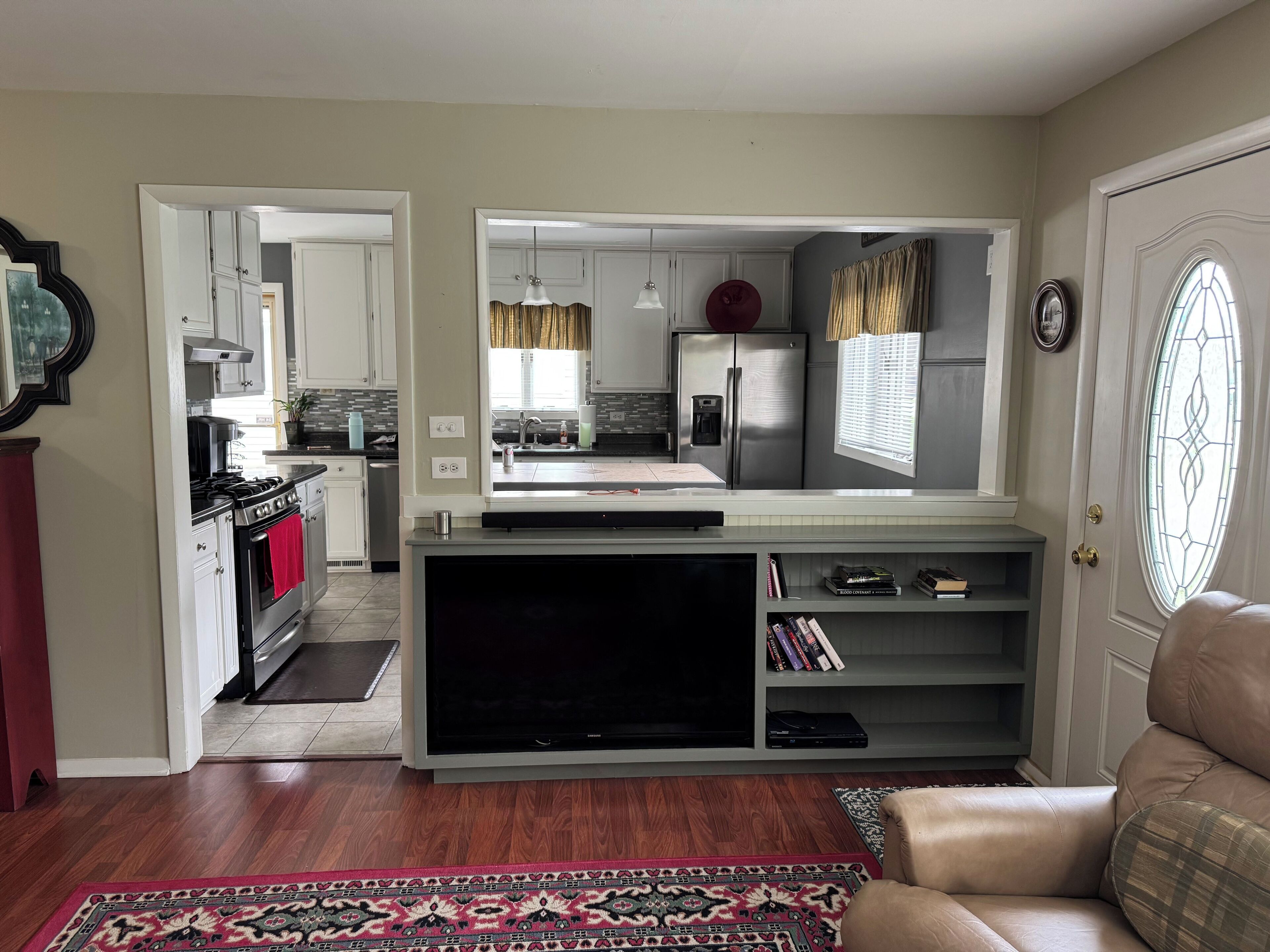 Un espacio habitable compacto con kitchenette, televisor de pantalla plana y una zona de estar acogedora.