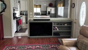 A compact living space with a kitchenette, a flat-screen TV, and a cozy seating area.