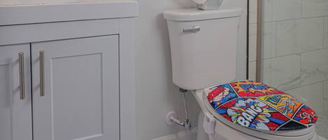 Une salle de bain comprenant des toilettes, un lavabo, un meuble de rangement et une fenêtre.