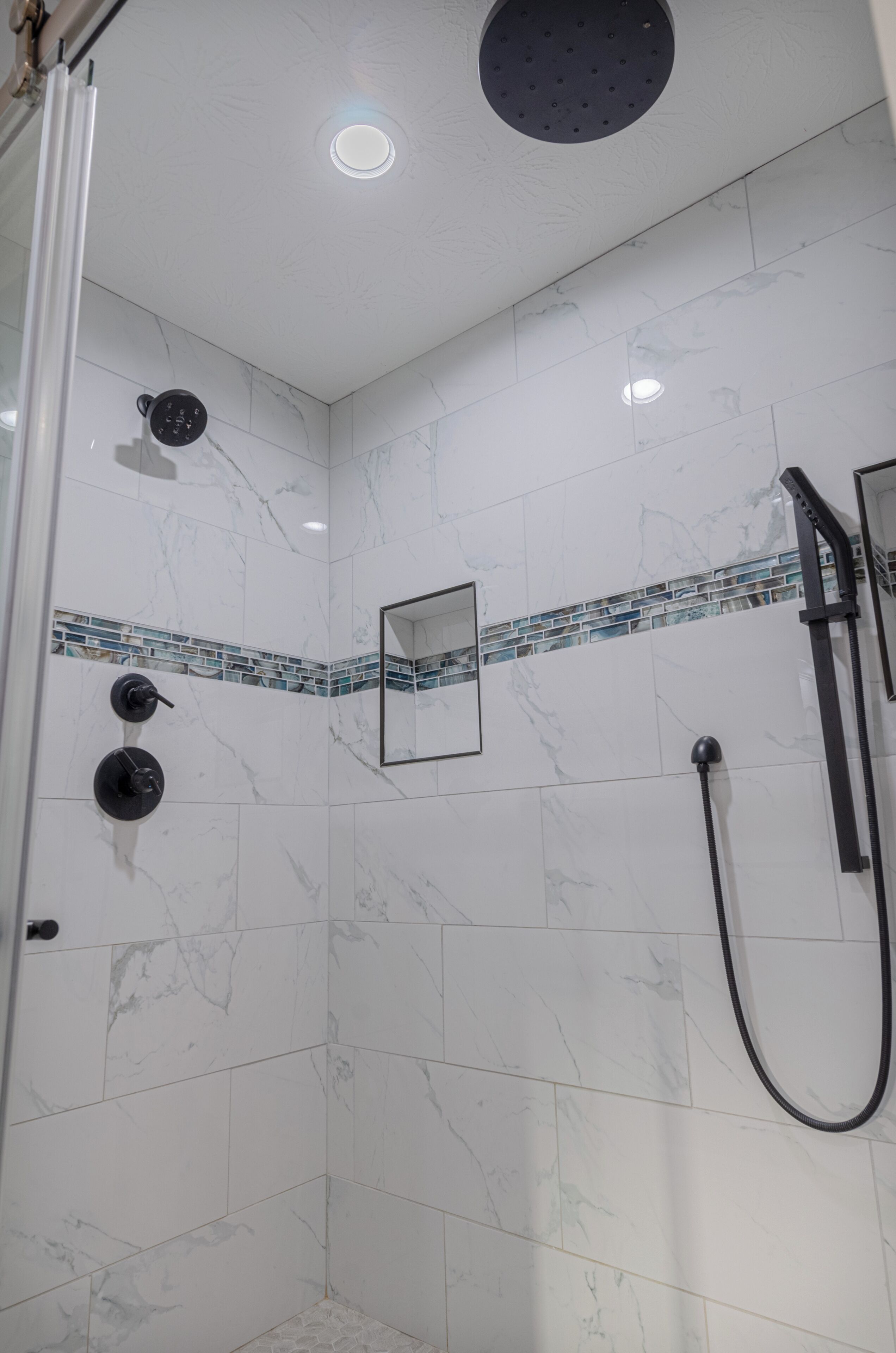 Eine Dusche mit Duschbrausehalterung und Wandarmatur.