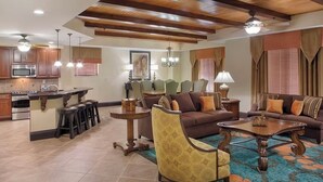 A spacious living area with a sofa, armchairs, and a coffee table. There is a kitchen area with a microwave and a bar stool. - Christmas at Disney! Spacious 2BR Condo w/ Lazy Rivers, Pools, & Fireworks View (Lake Buena Vista)