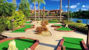 A golf course with green fairways, sand bunkers, and a water hazard. - Christmas at Disney! Spacious 2BR Condo w/ Lazy Rivers, Pools, & Fireworks View (Lake Buena Vista)