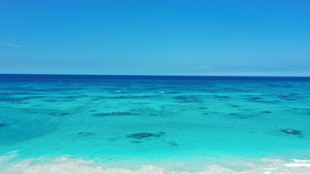 A clear view of a beach with turquoise water and white sand. - Brand New Designer Home on Banks Road, Steps from Beach, Walk to La Bougainvillea (Governor's Harbour)
