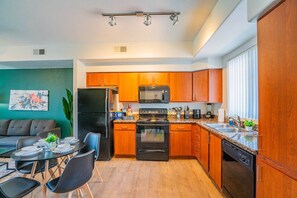 A compact kitchen with wooden cabinets, a refrigerator, microwave, stove, and dishwasher. - Walk To Westgate w/ Modern Pool, Gym, Parking, W/D (Glendale)