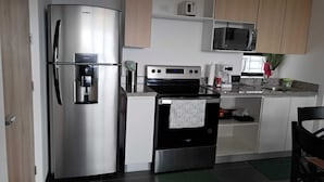 A modern kitchen with stainless steel appliances, including a refrigerator, oven, and microwave.