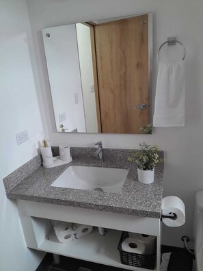 Een haardroger, handdoeken, zeep, toiletpapier