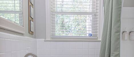 A bathroom with a white sink, toilet, and shower curtain.