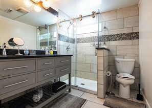 Een douche, handdoeken, zeep, toiletpapier