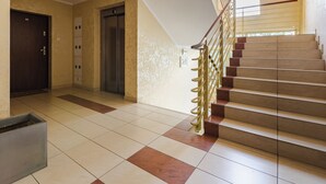 A staircase with a handrail, a door, and an elevator.
