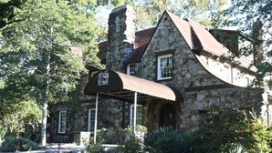 A stone building with a brown roof and a covered patio area. - Cozy Mountain Cabin w/ Creek, near Dining & Hiking (Monteagle)