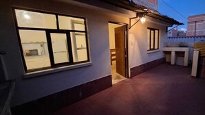 Un immeuble résidentiel doté d’un patio couvert, d’une cuisine ouverte avec un four à micro-ondes et d’une porte donnant sur un espace intérieur.