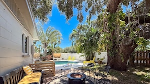 A backyard with a pool, outdoor furniture, and a large tree. - 3BR Largo Retreat w/ Private Pool & Patio (Largo)