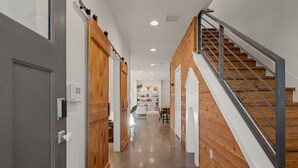 A modern hallway with wooden walls and a staircase with metal railings. - Group-Friendly 4BR | Steps from East Austin Fun (Austin)
