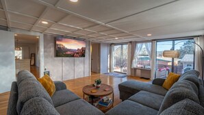 Ett rymligt vardagsrum med en stor soffgrupp, ett soffbord och en tavla på väggen.