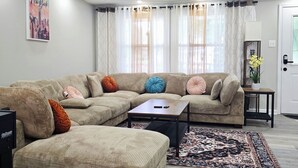 A modern living room with a sectional sofa, a coffee table, and a patterned rug. - Spacious & beautiful 4-bedroom in a peaceful Severn, close to DC & Baltimore (Severn)